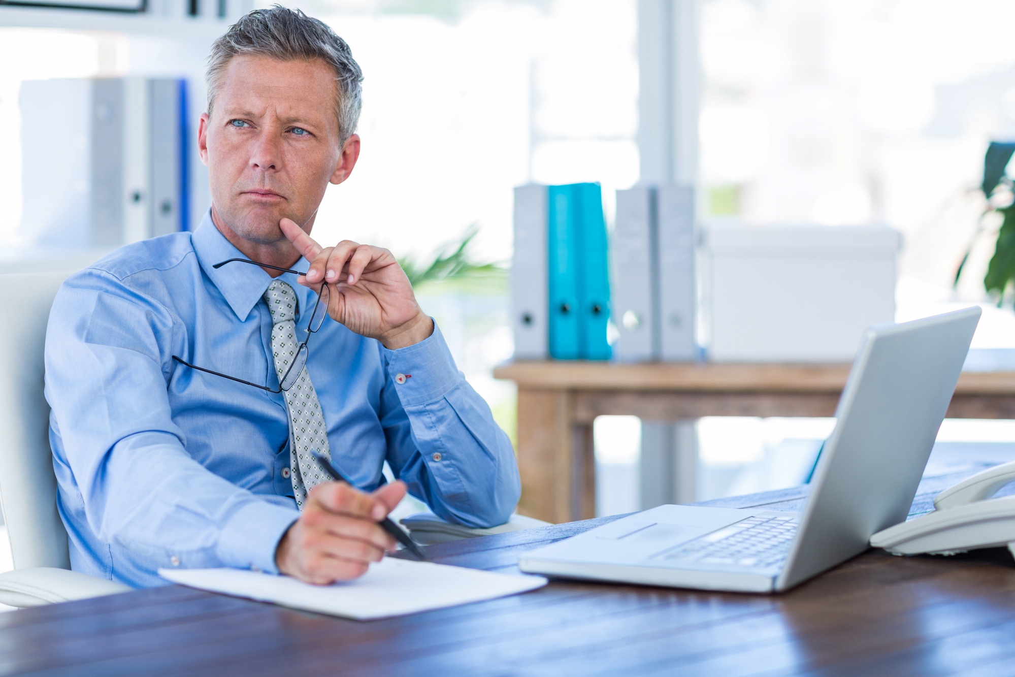 Thoughtful businessman with a laptop
