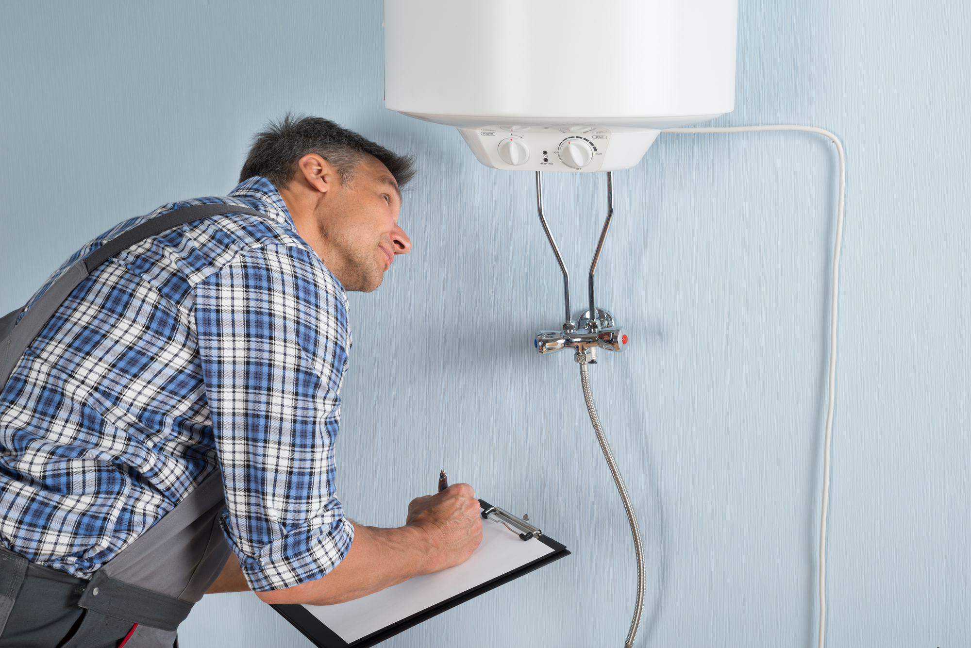 Elderly man checking the hot-water boiler