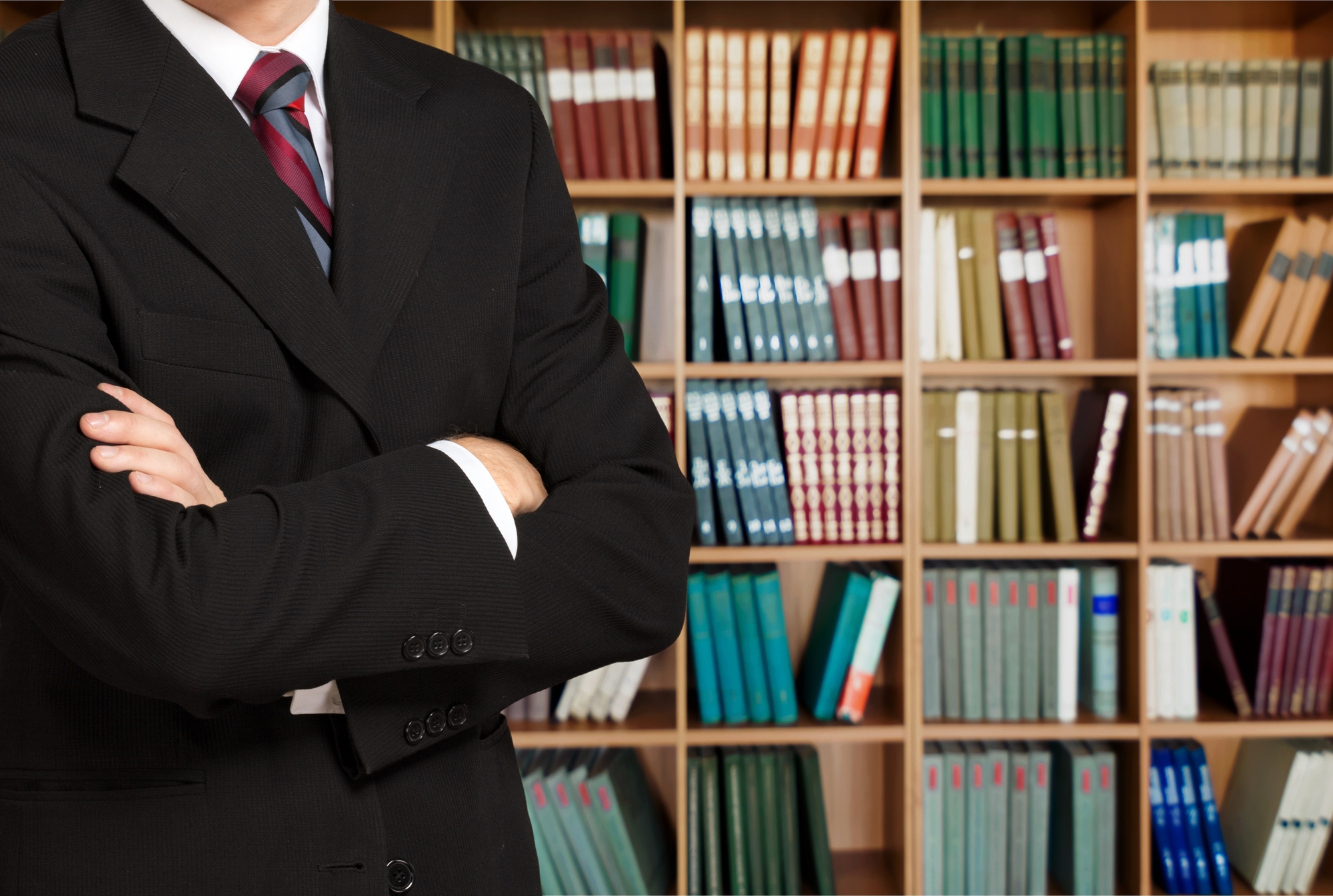 Man in a library with his arms crossed