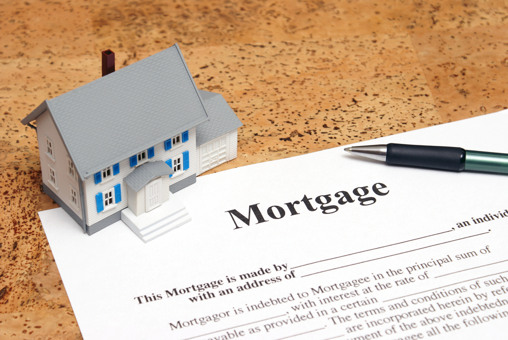 Toy house and mortgage form with pen